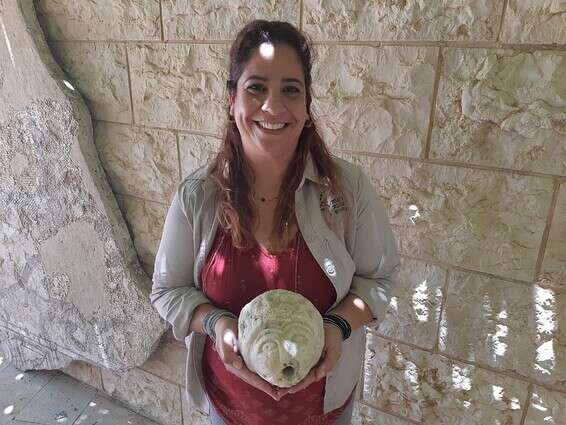 מיטל רויזר אהרון עם התגלית הארכיאולוגית // צילום: ראובן ריבן, רט"ג 